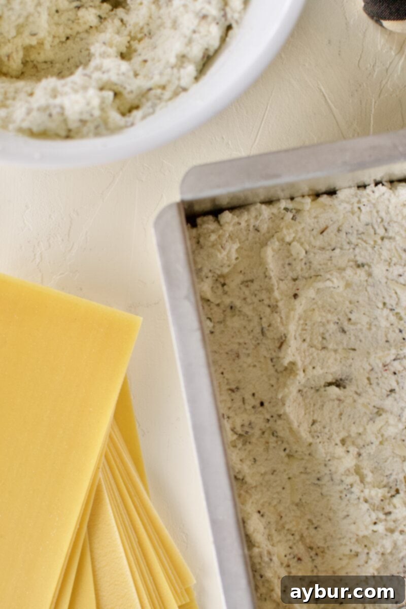 The third delicious layer of homemade lasagna: a thick, even spread of creamy, seasoned ricotta cheese over the oven-ready noodles.