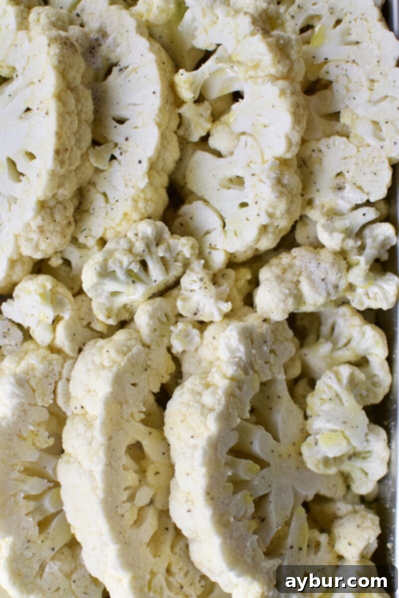 Cheesy Cauliflower and Leek Gratin 4 Raw cauliflower steaks seasoned with olive oil and truffle salt, ready for roasting.