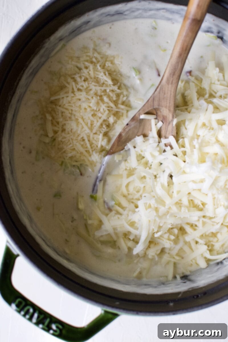 Cheesy Cauliflower and Leek Gratin 8 Shredded Gruyere and Parmesan cheeses being stirred into the rich cream sauce.