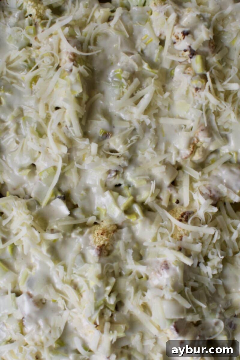 Cheesy Cauliflower and Leek Gratin 9 Roasted cauliflower topped with creamy Gruyere cheese sauce, ready for final baking.