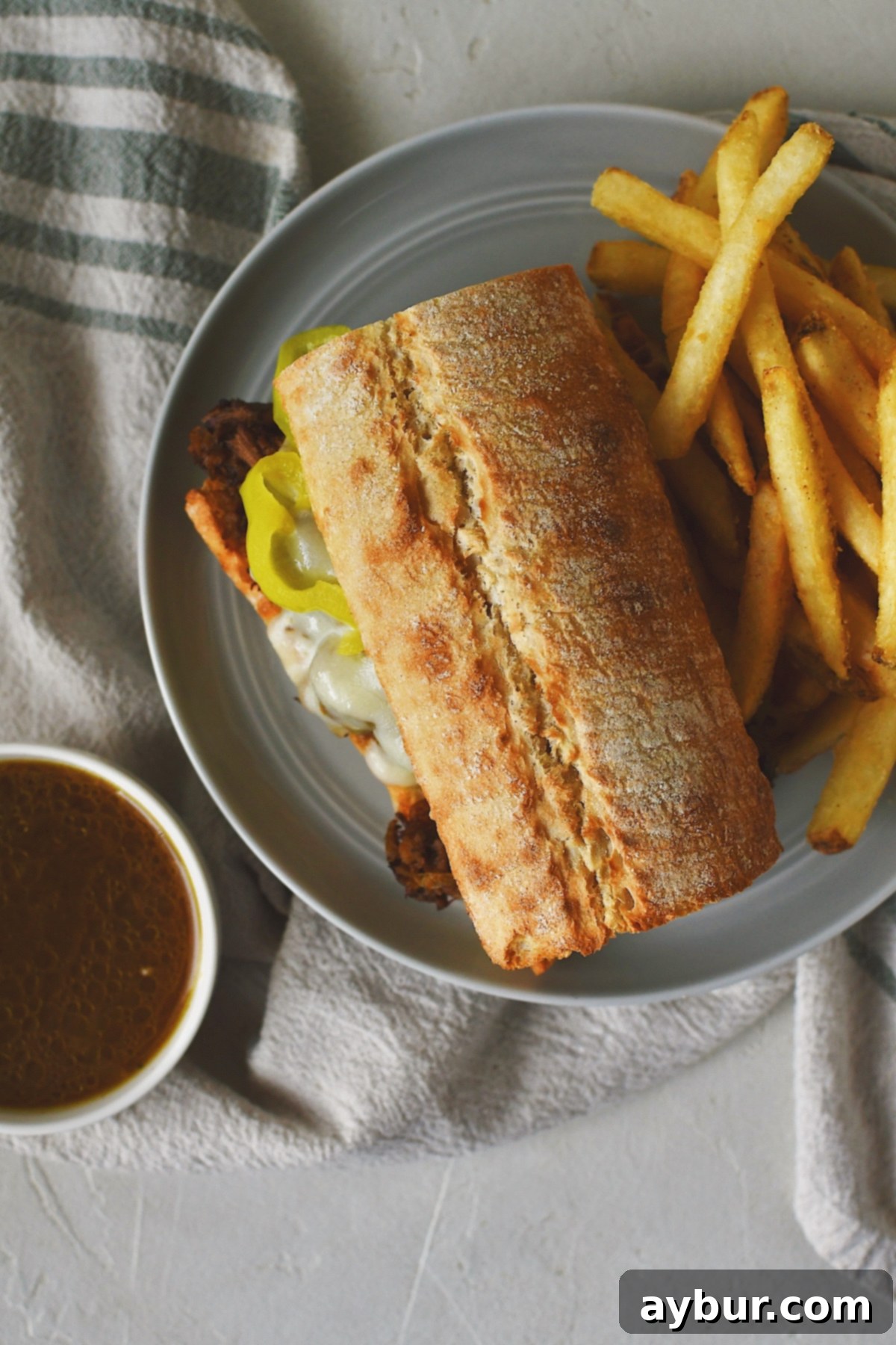 Savory Pot Roast Sandwiches 4 Looking down at a pot roast sandwich with a side of fries and jus for dipping.