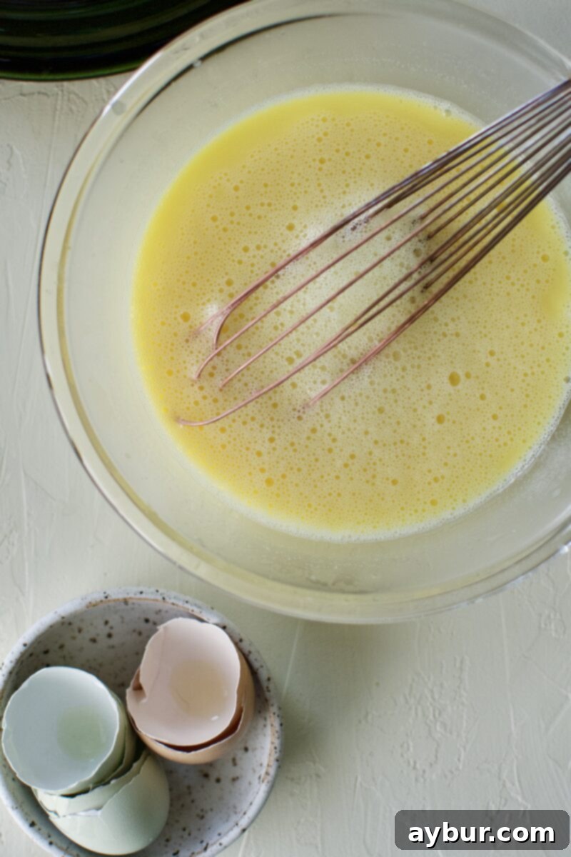 Zesty Greek Avgolemono Chicken Rice Soup 6 Tempered egg and lemon mixture slowly combined with warm chicken stock, demonstrating the tempering process for Avgolemono.