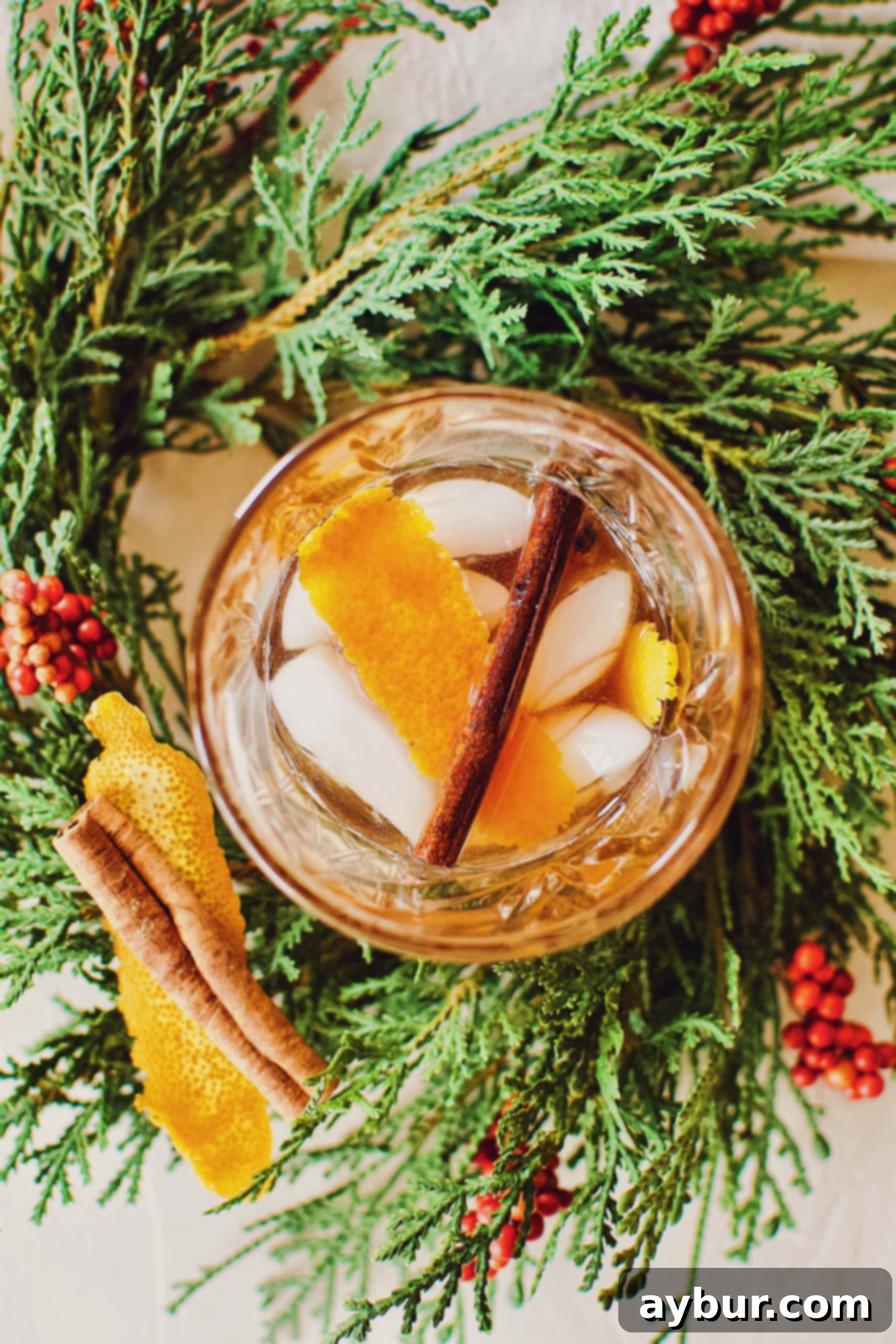 A beautifully garnished Bourbon Brown Sugar Old-Fashioned cocktail nestled within a festive holiday wreath.