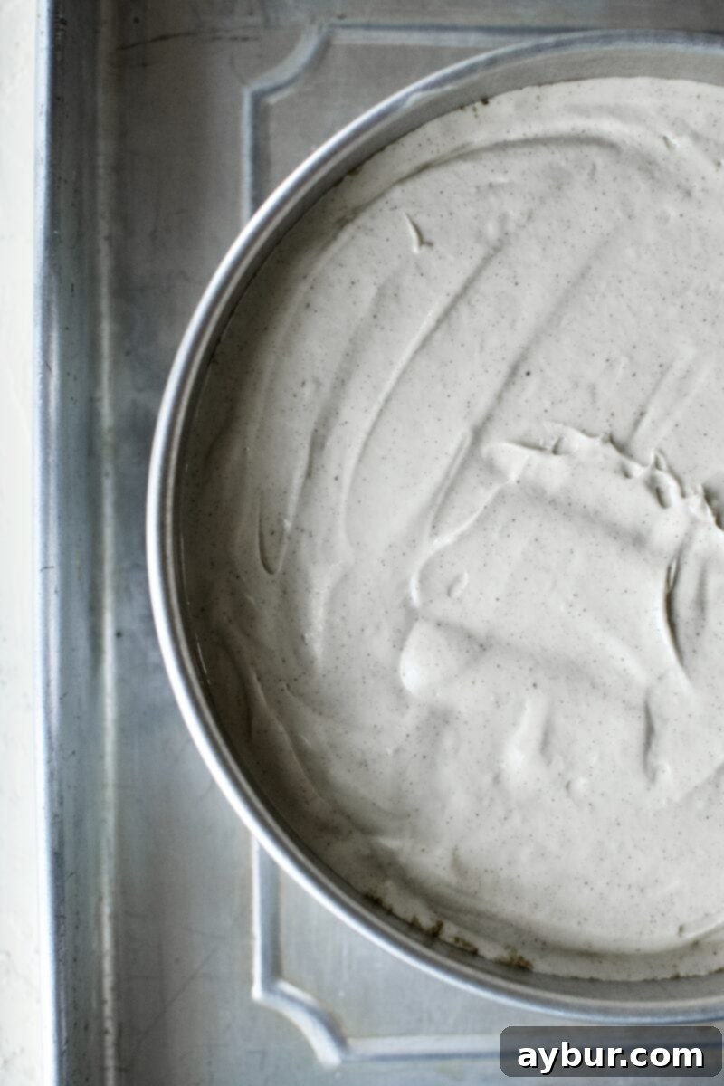 Cheesecake batter in a water bath, placed in a larger roasting pan filled with water, ready to be baked in the oven.