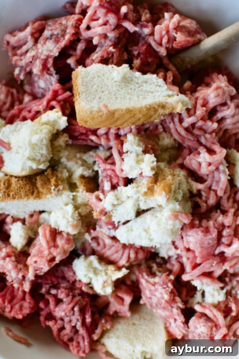 Mega Meatball Masterpiece 5 A large bowl containing soaked Texas Toast, ground pork, ground beef, and Italian sausage, ready for mixing.