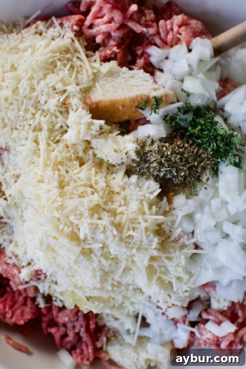 Mega Meatball Masterpiece 7 All raw meatball ingredients combined in a large bowl, ready for the mixing process.