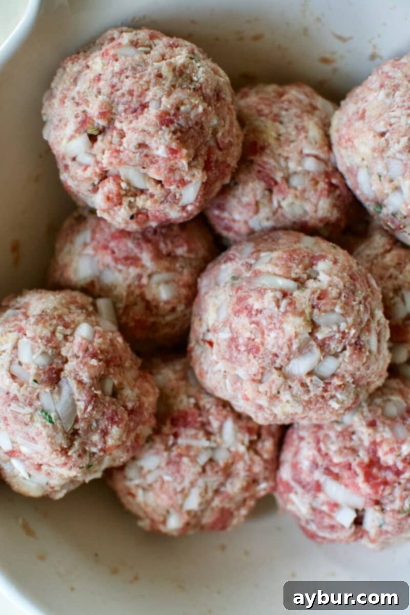 Mega Meatball Masterpiece 10 All nine perfectly portioned giant meatballs, ready for baking on a parchment-lined sheet.