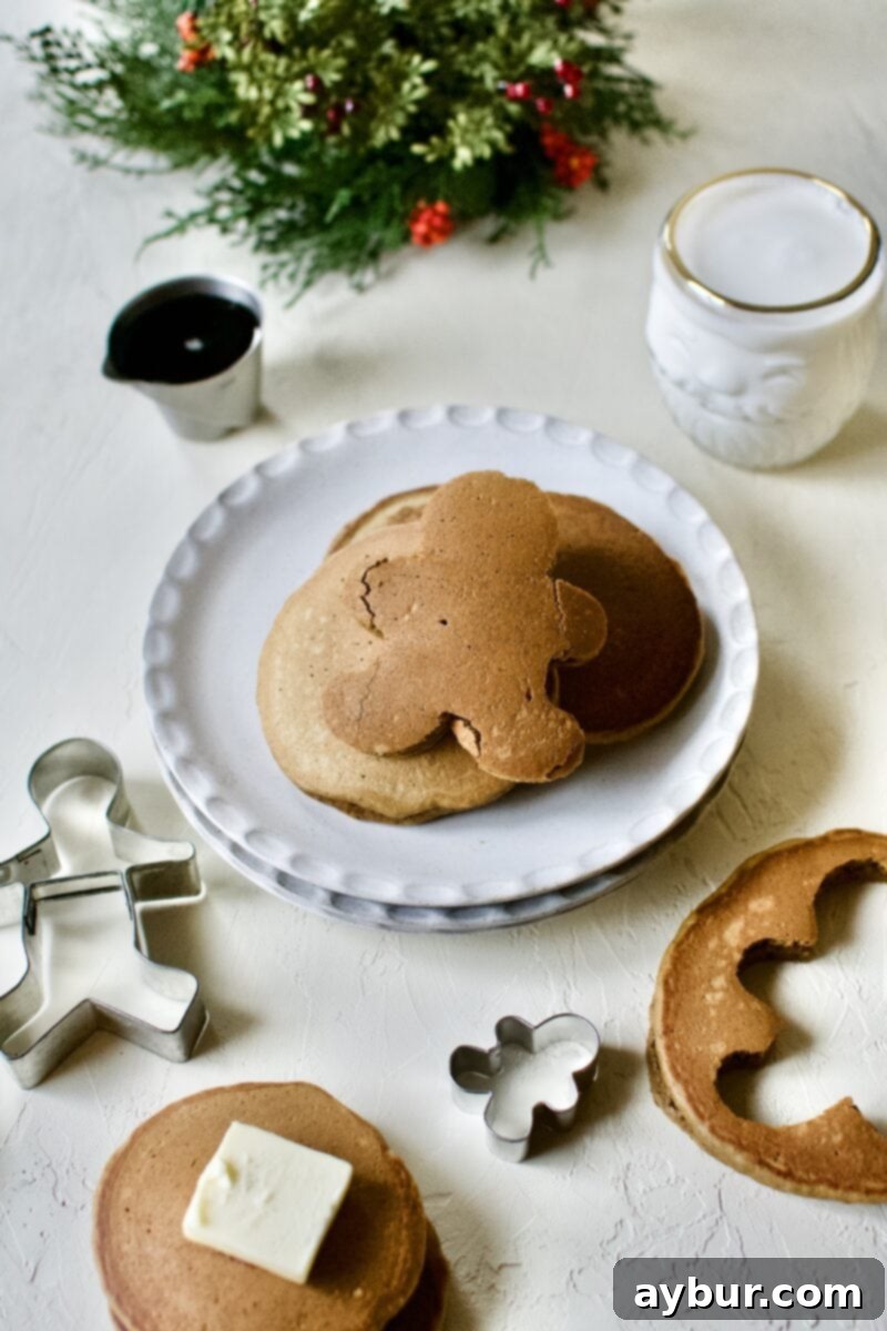 A whimsical stack of golden Gingerbread Pancakes, with one pancake expertly cut into the charming shape of a gingerbread man, adding a playful touch to the festive breakfast.
