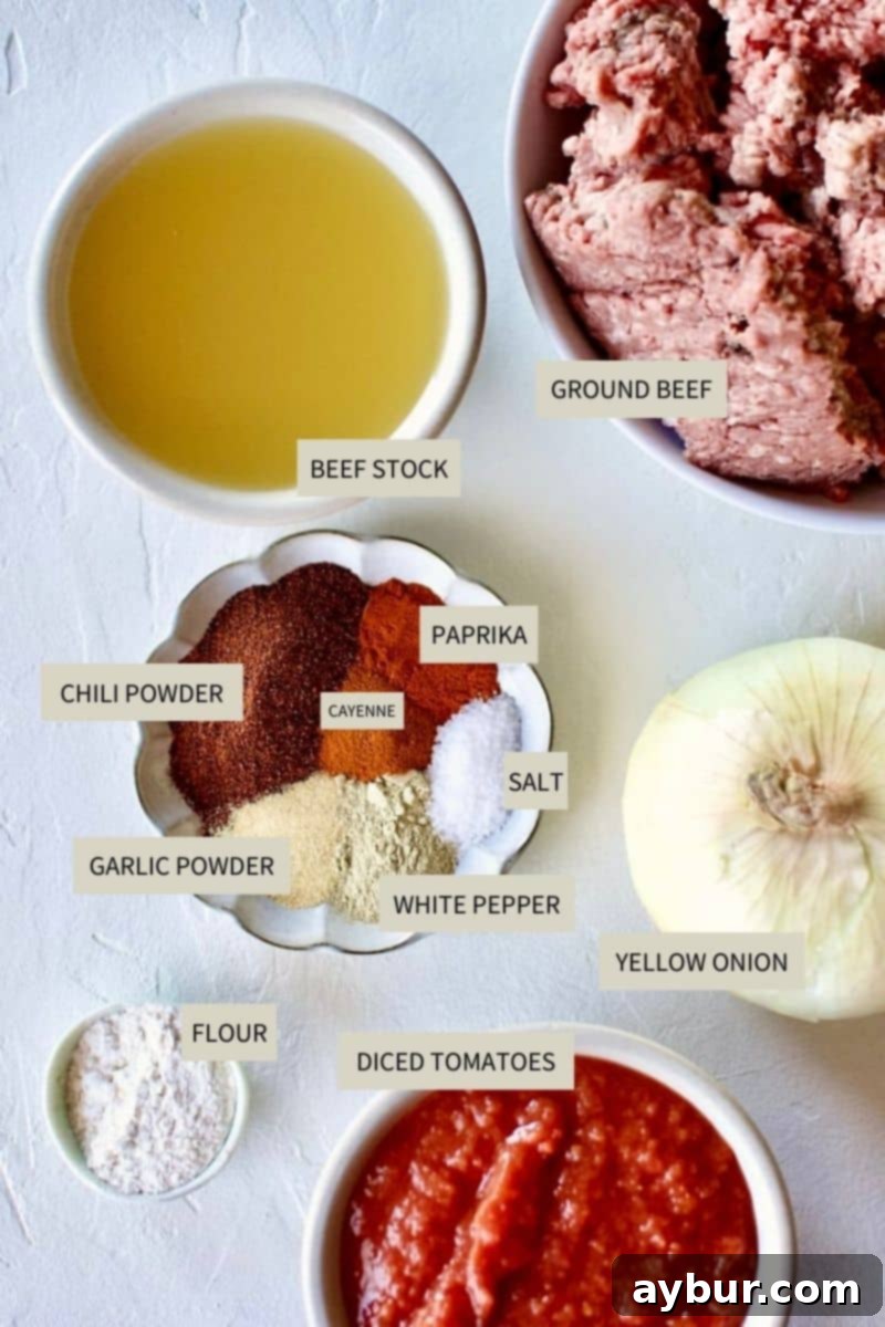 A collection of fresh ingredients laid out: diced yellow onion, ground beef, various spices in small bowls, and canned crushed tomatoes.