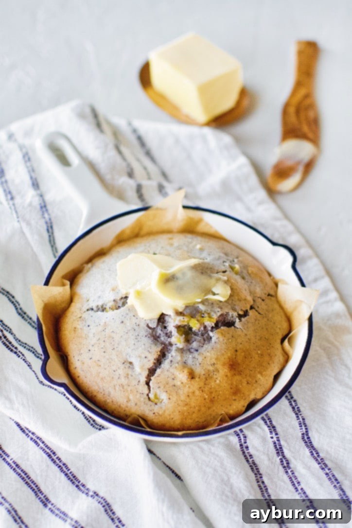 A perfectly baked blue cornbread in a cast-iron skillet, glistening with melted butter and ready for a hearty meal.