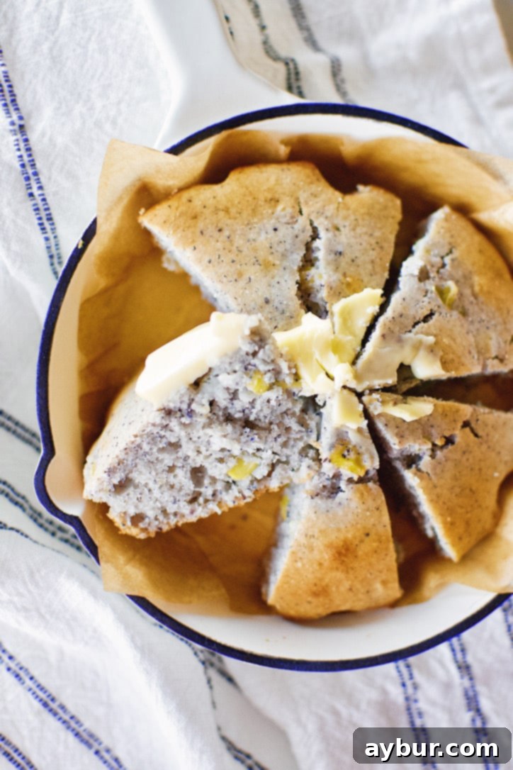 A vibrant blue cornbread baked in a skillet, glistening with melted butter and ready for a hearty meal.