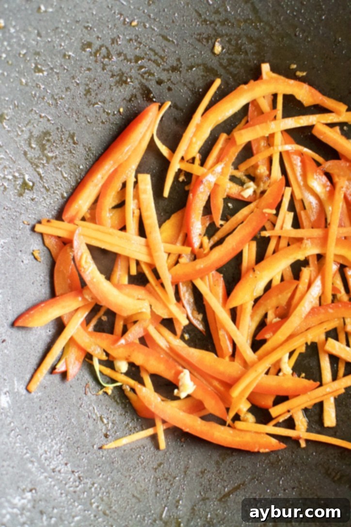 Easy Homemade Lo Mein Just Like Takeout 5 Carrots, Bell Peppers, and ginger cooking in a hot wok.