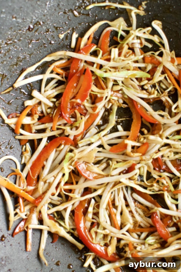 Easy Homemade Lo Mein Just Like Takeout 6 Cabbage, garlic, bean sprouts, and sauce added to the hot wok.