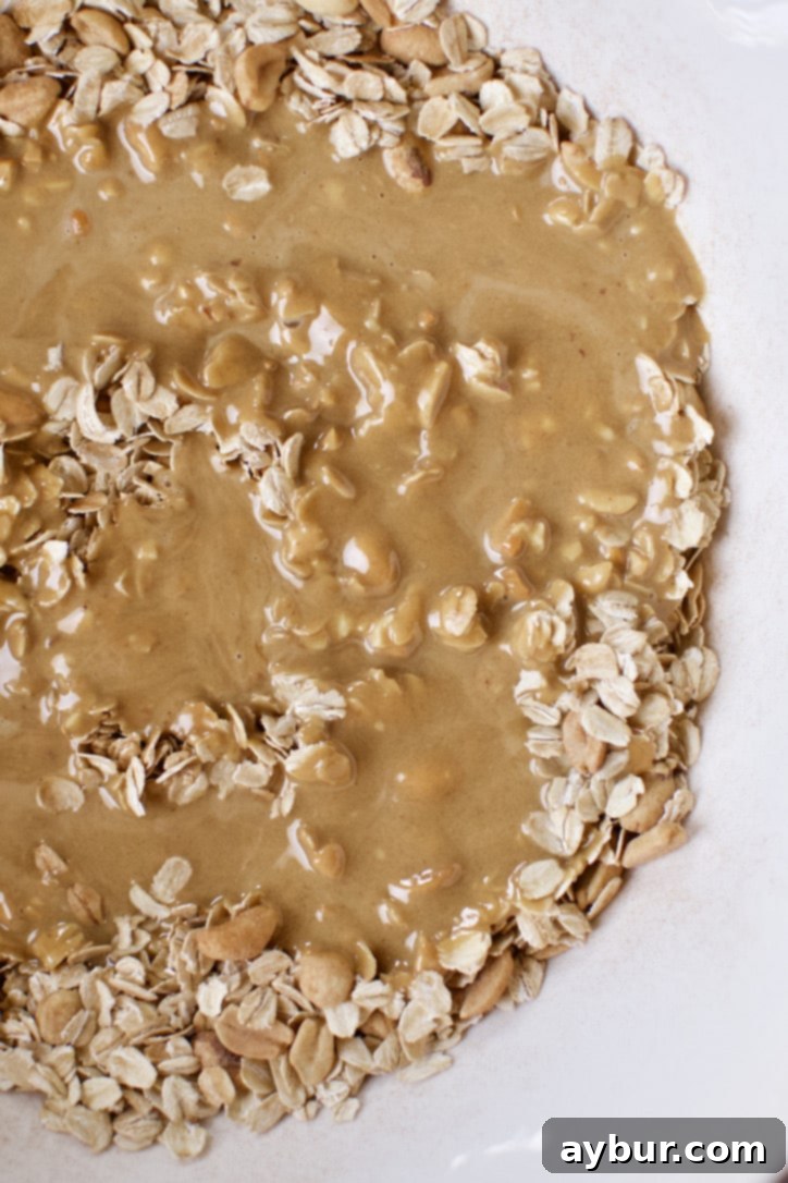 Ultimate Peanut Butter Granola Crunch 8 Crunchy Peanut Butter Granola ingredients mixed together in a bowl.