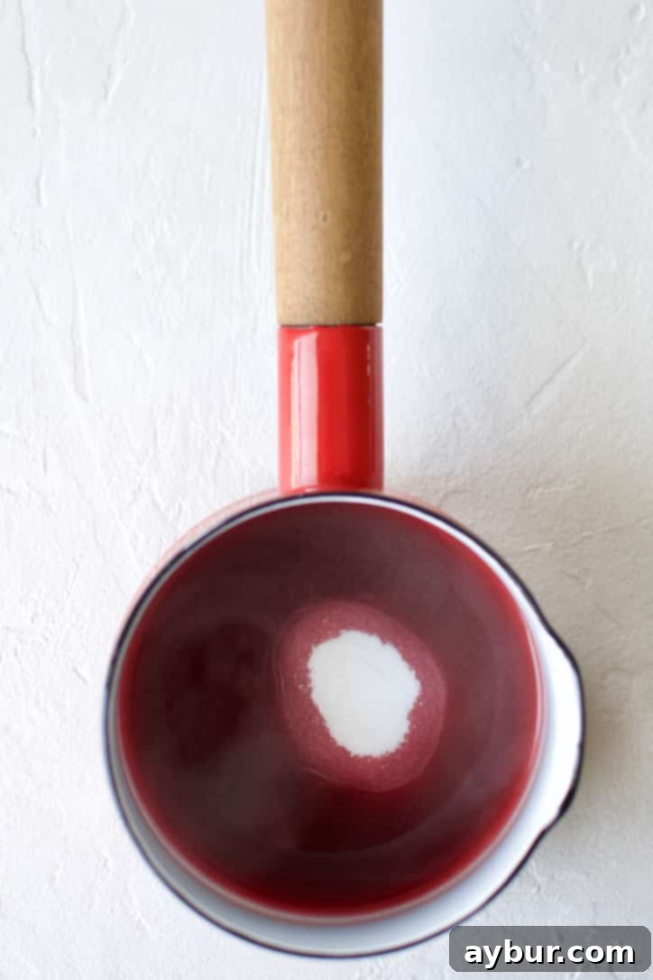 Blood Orange Juice and sugar in a pan ready to be boiled to make a blood orange simple syrup.