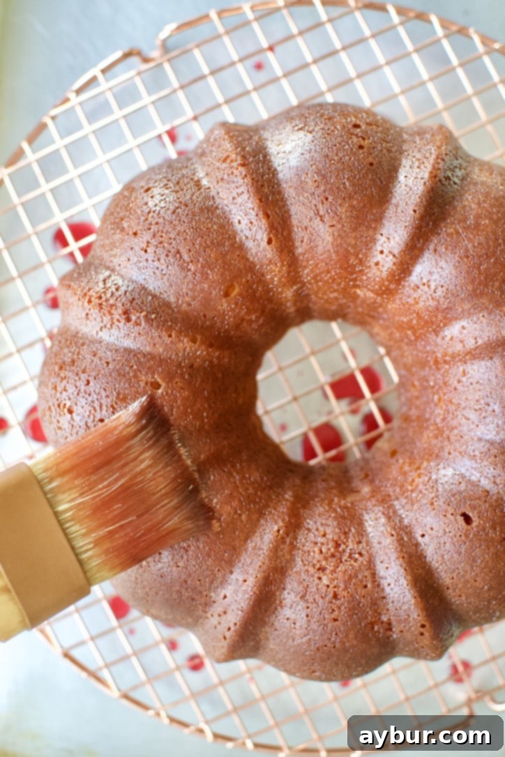 Brushing the freshly baked cake with blood orange simple syrup.