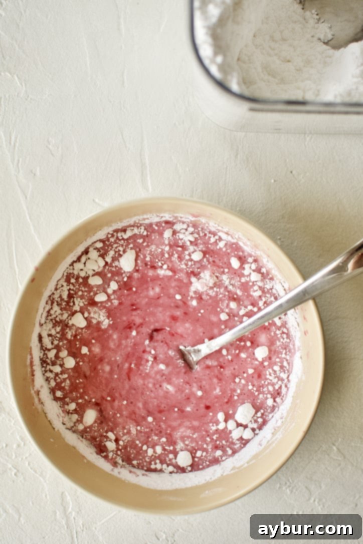 Mixing blood orange juice and powdered sugar together to make a glaze.