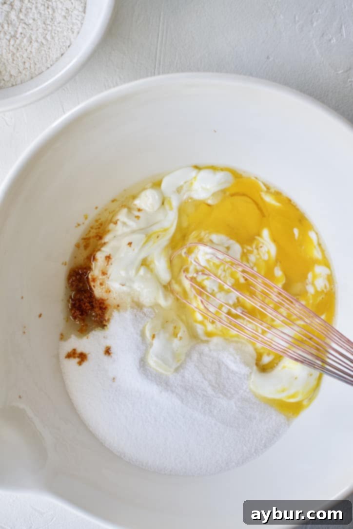 Blending the wet ingredients with the sugar in a bowl.
