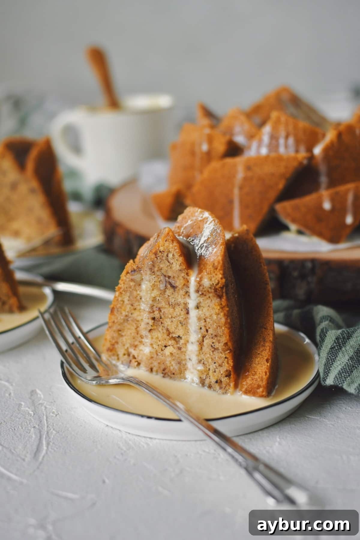 A generous slice of Brown Butter Cake, perfectly topped with rich Irish Whiskey Cream Sauce, which beautifully drips down the sides, highlighting the cake's moistness.