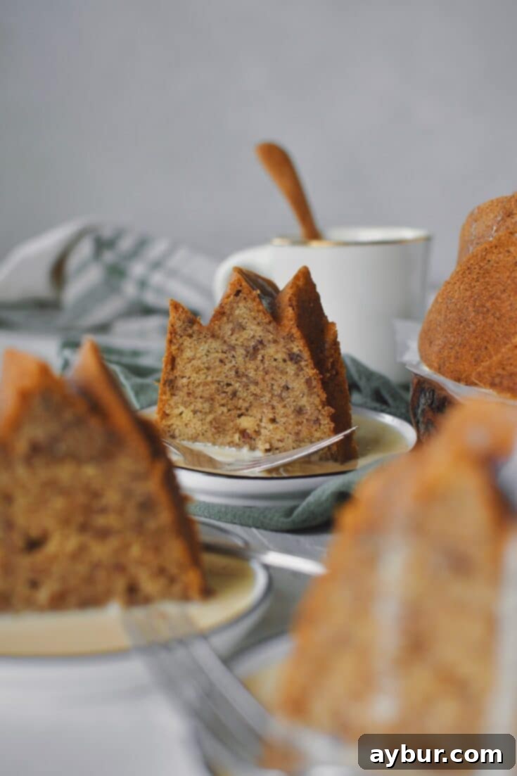 Brown Butter Cake sliced and topped with Irish Whiskey Cream Sauce, dripping off of the bundt cake.