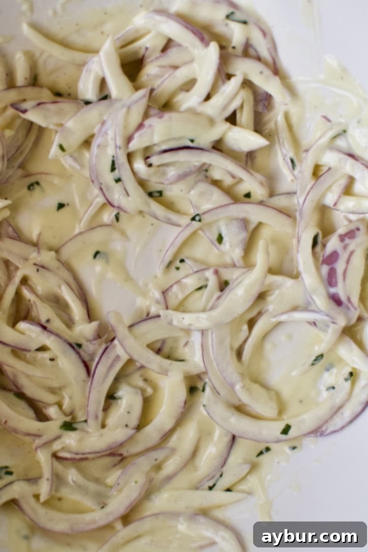 Red onions soaking in tarragon vinaigrette, starting the salad assembly.