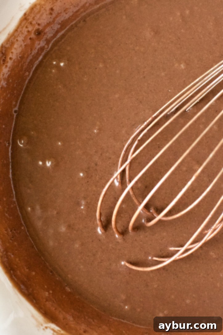 Whipping the chocolate milk and chocolate pudding mix together to form the pudding base.