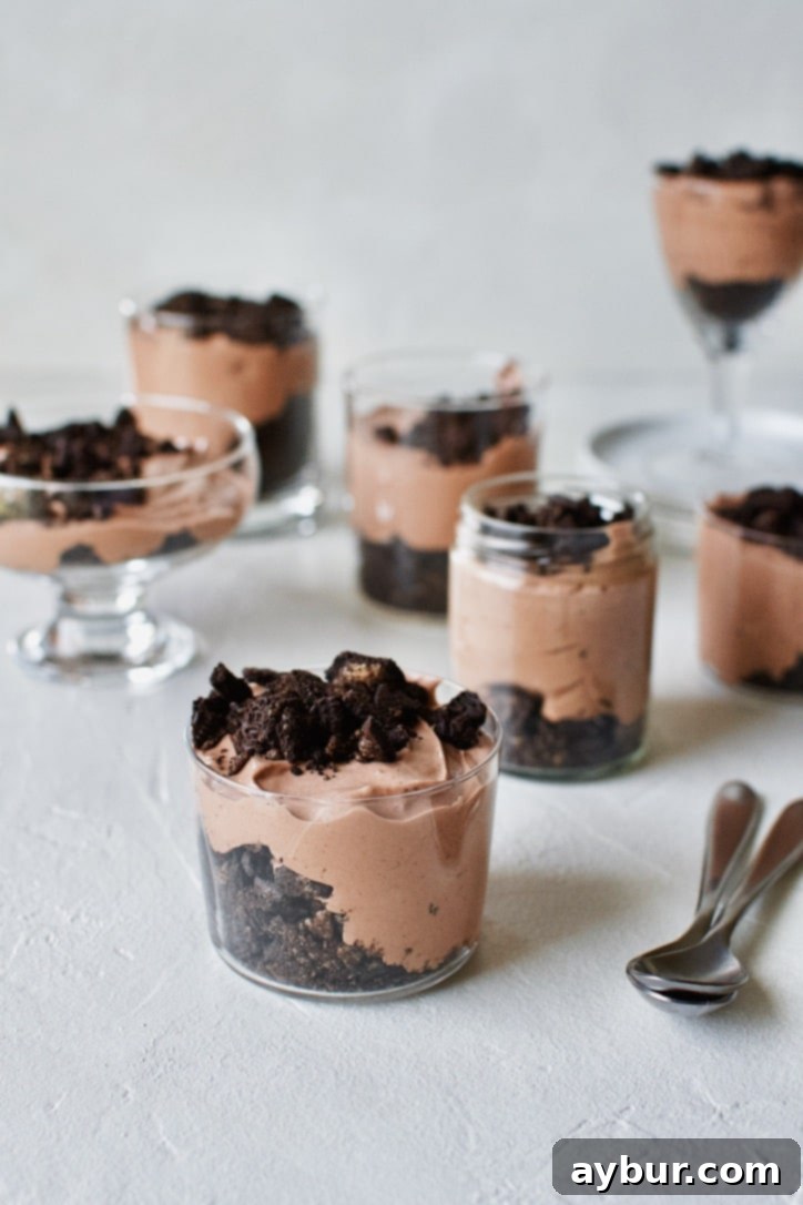 Layers of chocolate peanut butter Oreo dirt pudding and crushed cookies in individual serving cups.