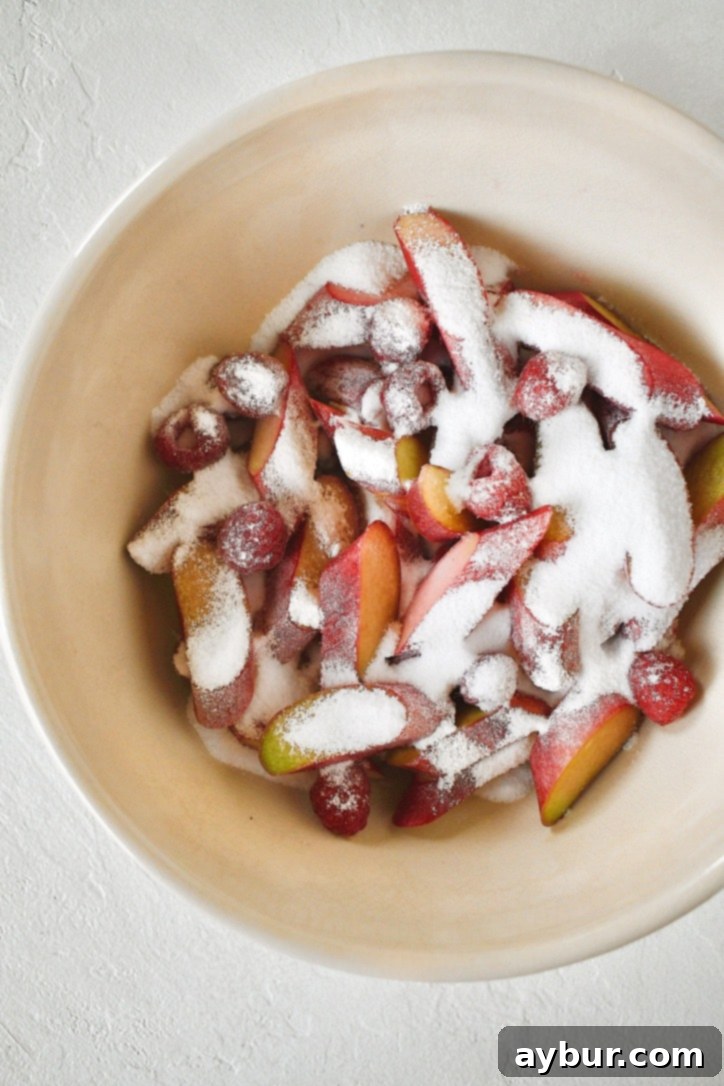 Rhubarb and Raspberries coated in sugar in a bowl, macerating.