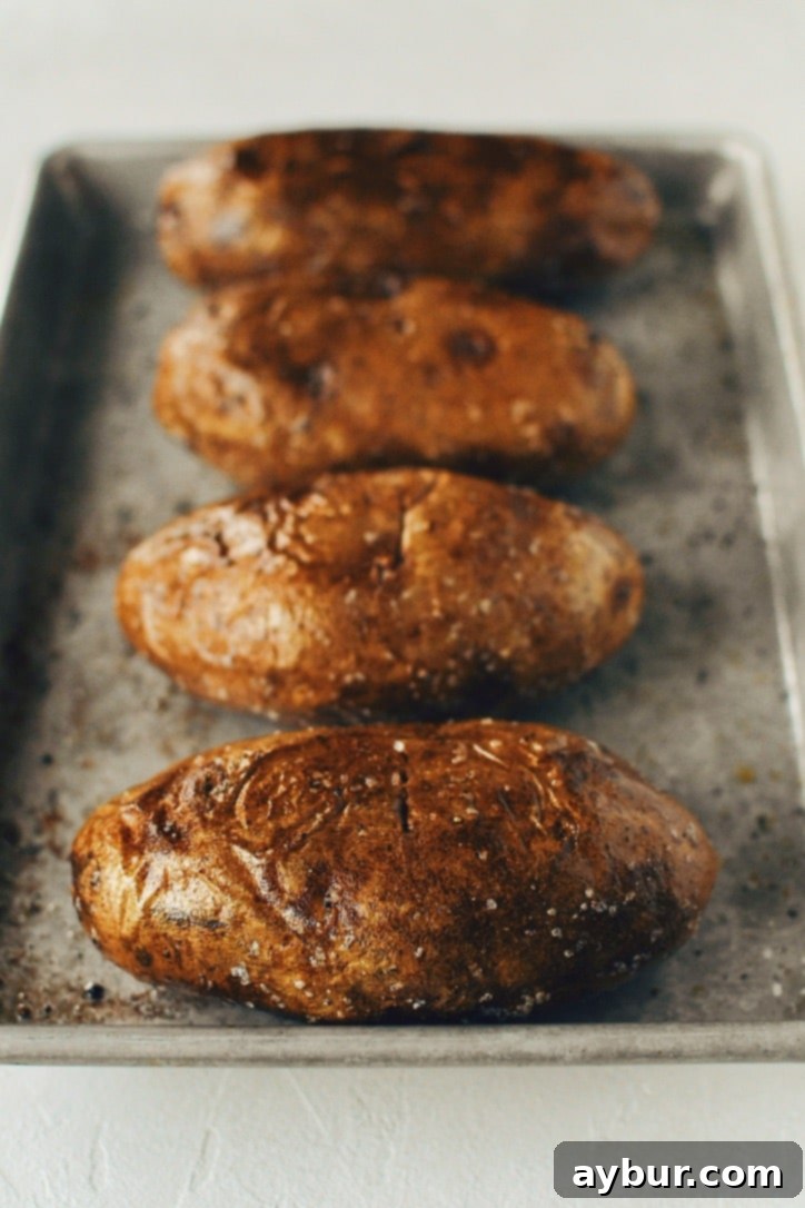 Crispy Skin Baked Potatoes fresh from the oven, showcasing their golden-brown, crunchy exterior.