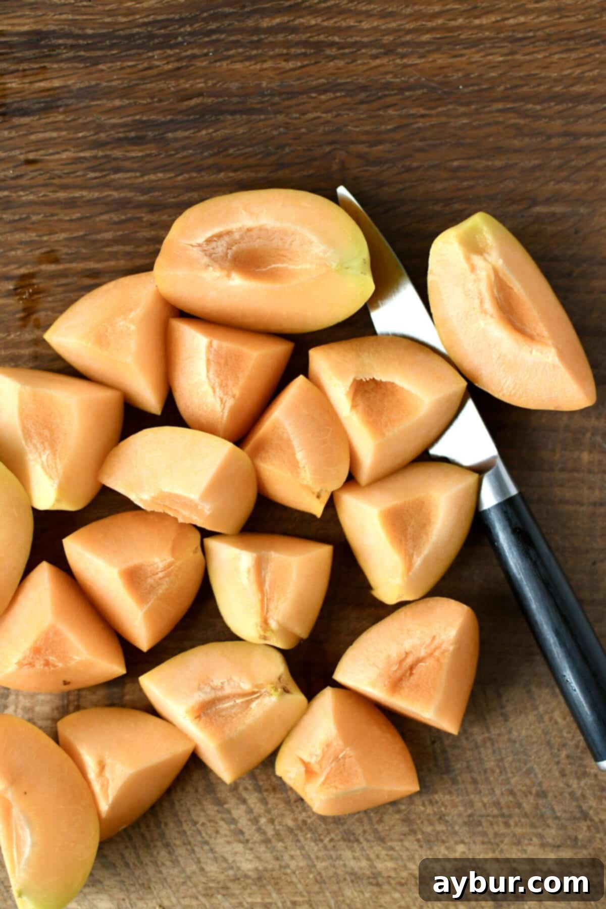 Golden Apricot Cobbler 4 Fresh, ripe apricots, diced into small, uniform pieces on a wooden cutting board, ready for the cobbler filling.