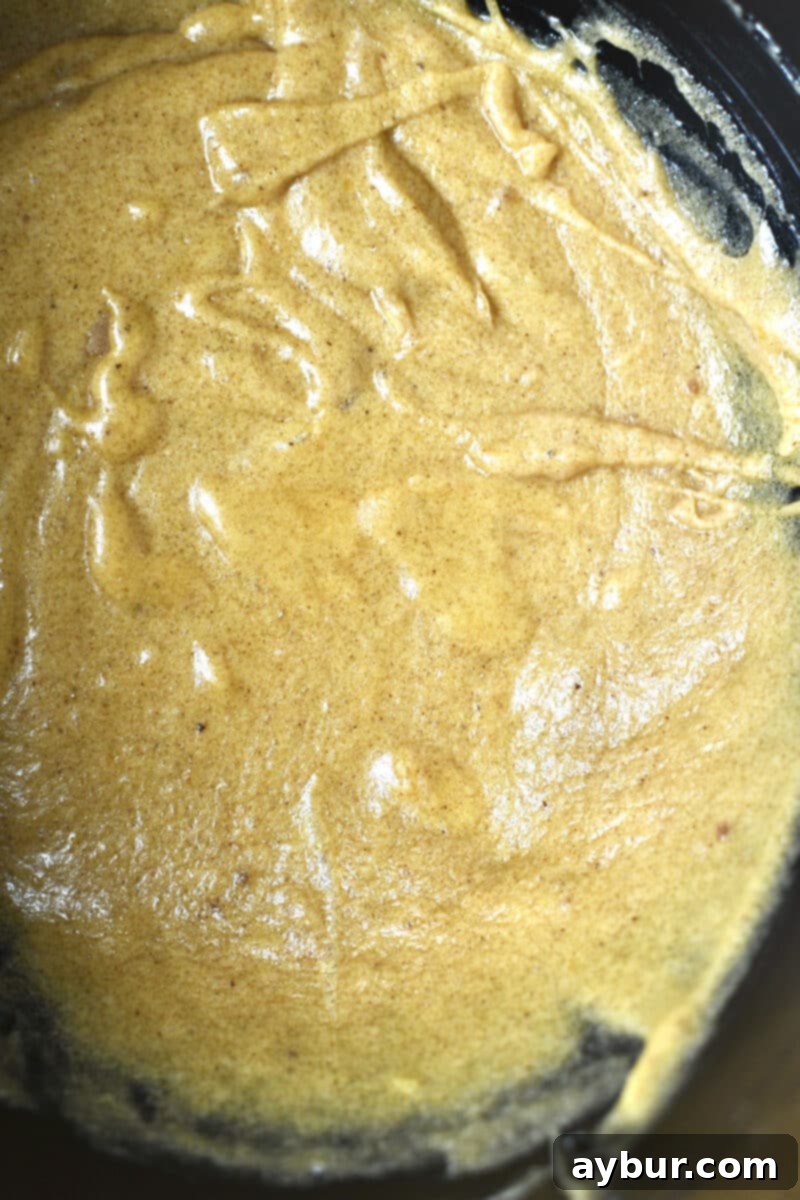 Nutty Brown Butter Banana Loaf 5 Banana bread batter with wet ingredients combined, before dry ingredients and walnuts are mixed in, showing a slightly separated, runny texture.