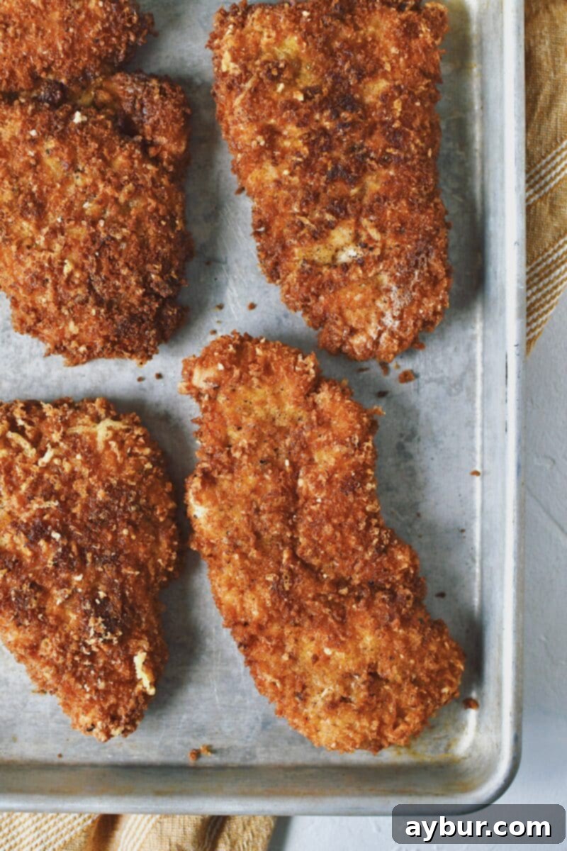 Freshly fried Crispy Parmesan Chicken cutlet, golden brown and ready for assembly.