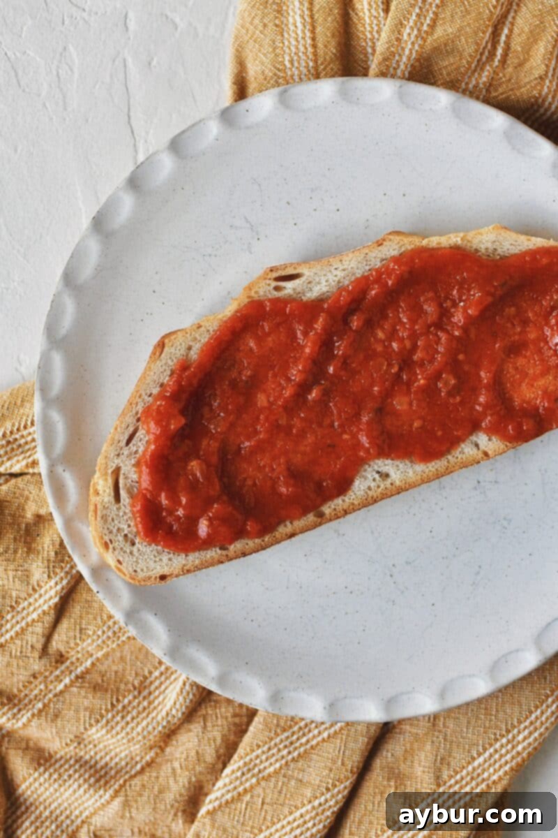 Toasted Italian bread slices with a layer of rich marinara sauce spread evenly, forming the base of the Parmesan Chicken Sandwich.