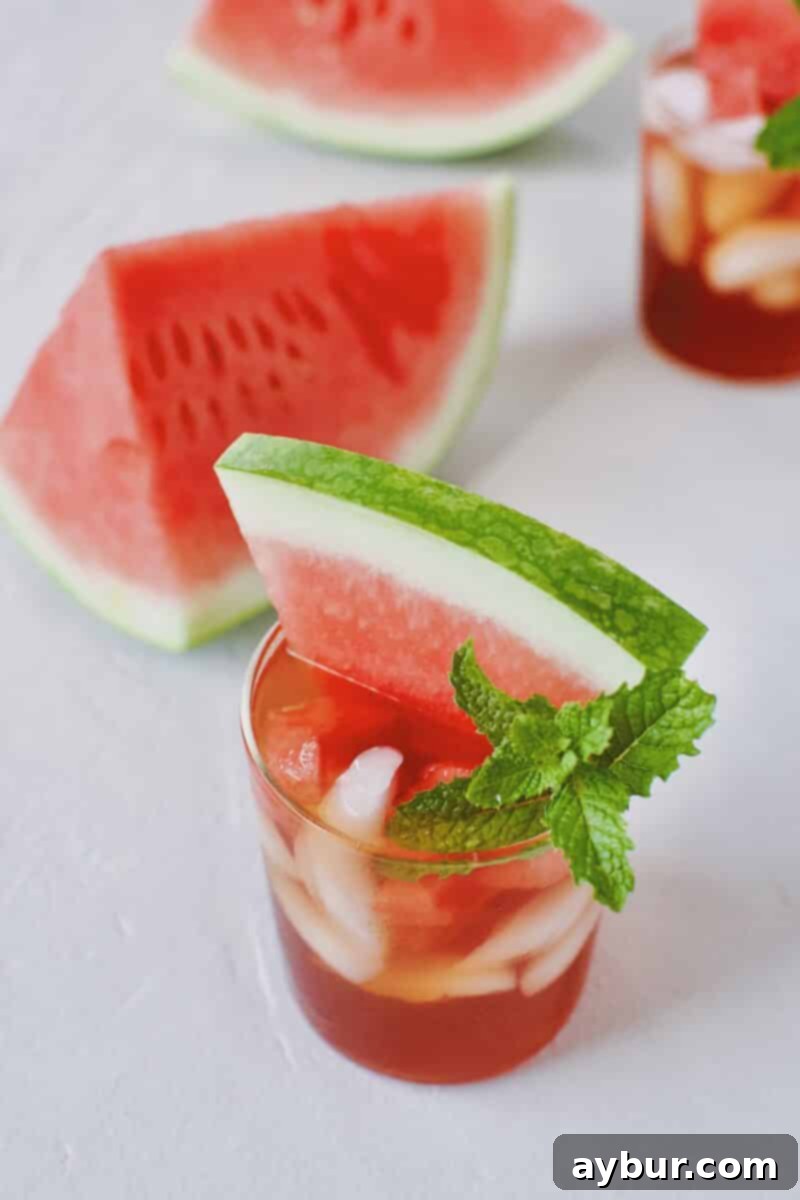 Close-up of Watermelon Sweet Tea Sangria in a glass with fresh fruit garnish.