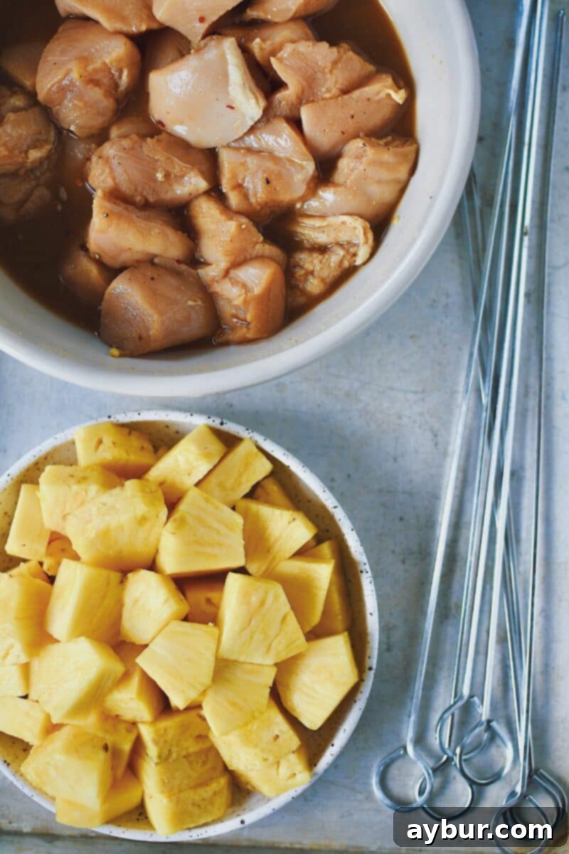 Tropical Peanut Chicken Skewers 5 Chicken marinating in an asian inspired pineapple sauce, and pineapple chunks ready to be skewered.