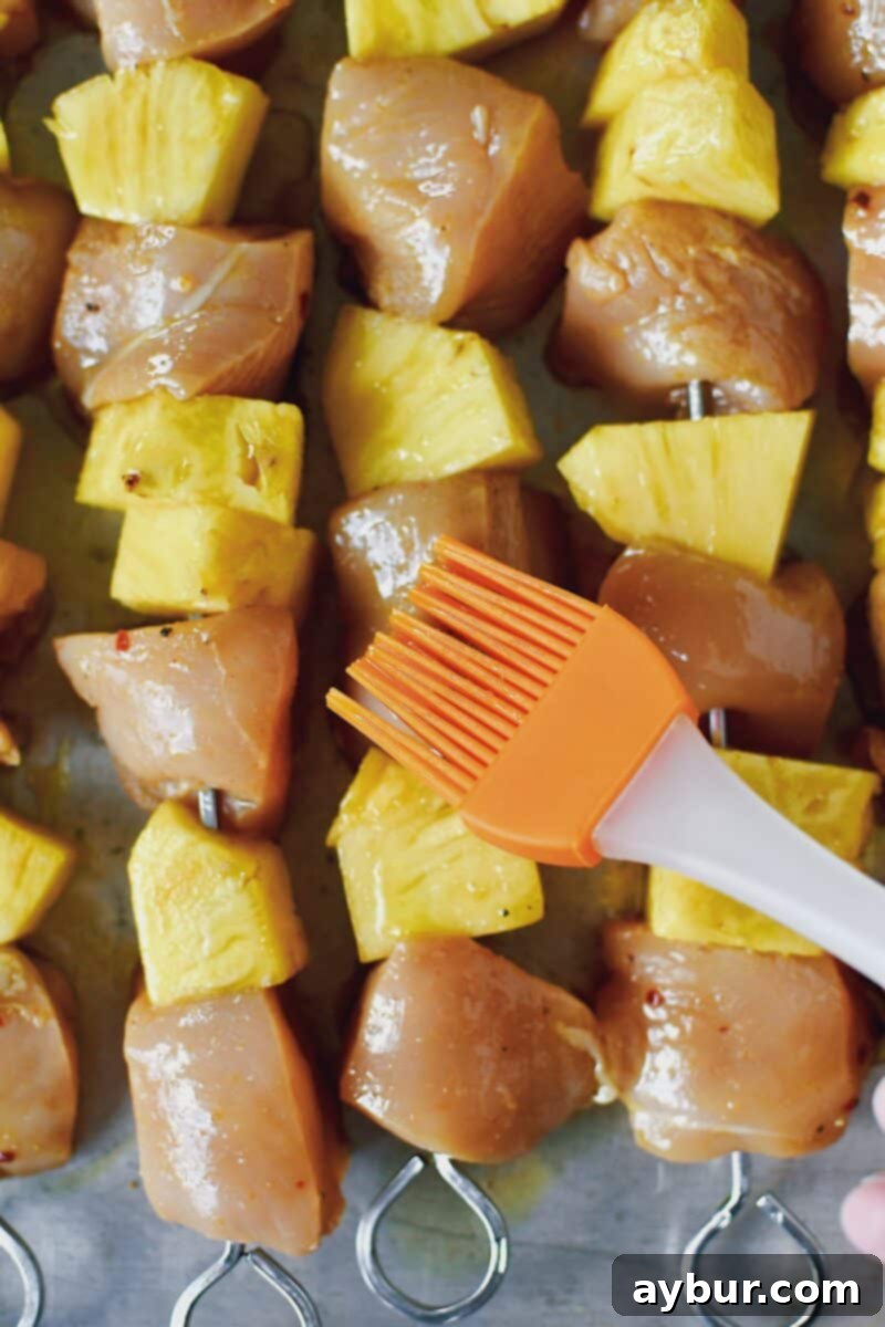 Tropical Peanut Chicken Skewers 7 Brushing the chicken and pineapple skewers with oil before grilling.