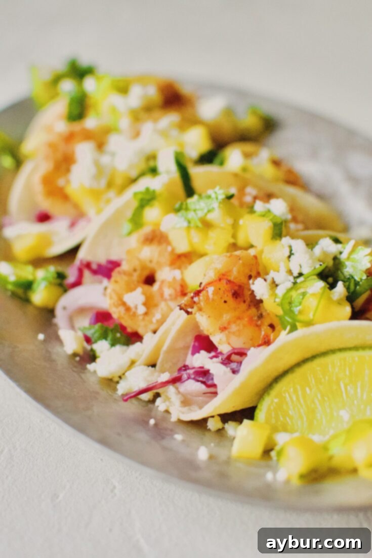 A beautifully arranged platter of Baja Shrimp Tacos, garnished with fresh toppings, ready to be served.