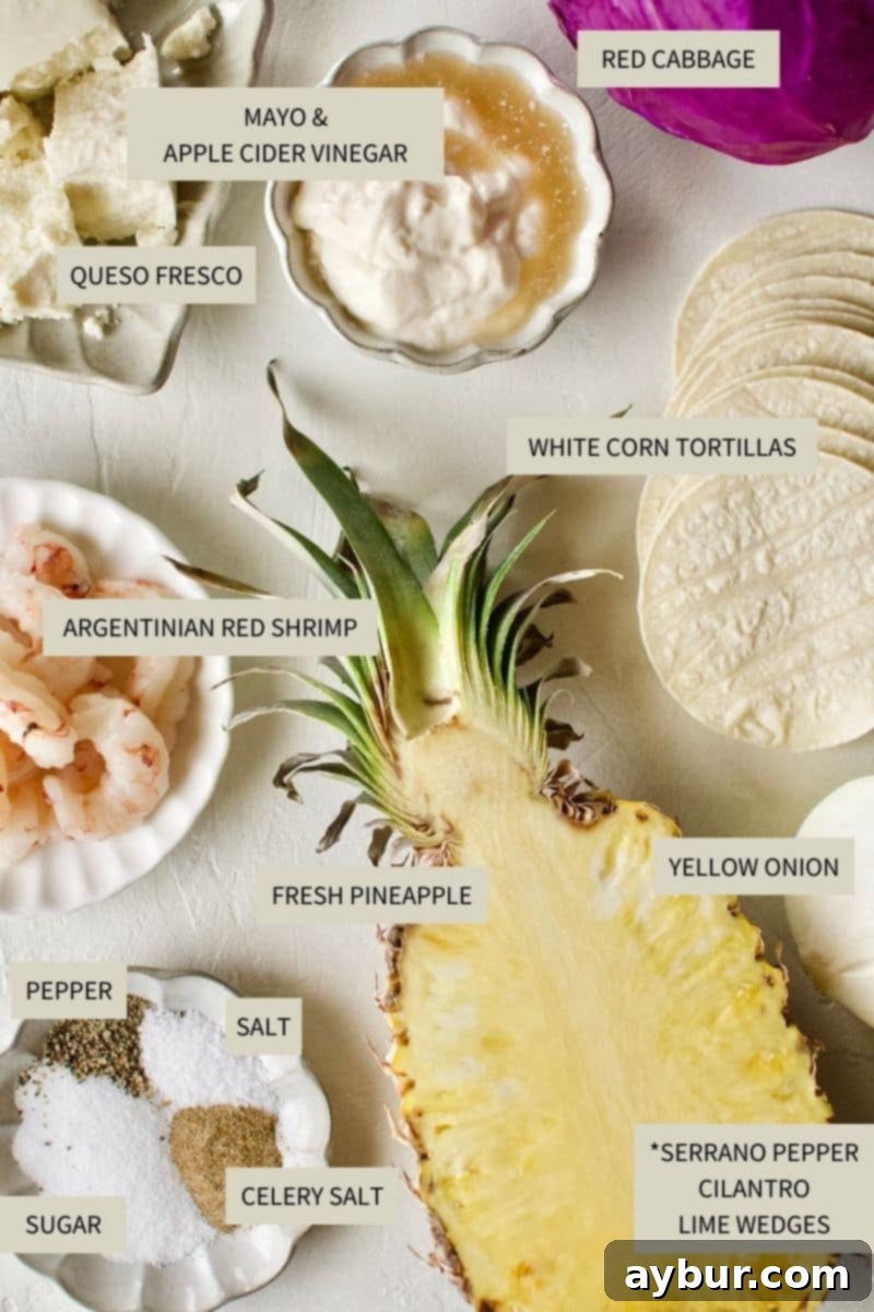 A selection of fresh ingredients laid out, including Argentinian Red Shrimp, red cabbage, pineapple, serrano peppers, cilantro, and limes, ready for making Baja Shrimp Tacos.