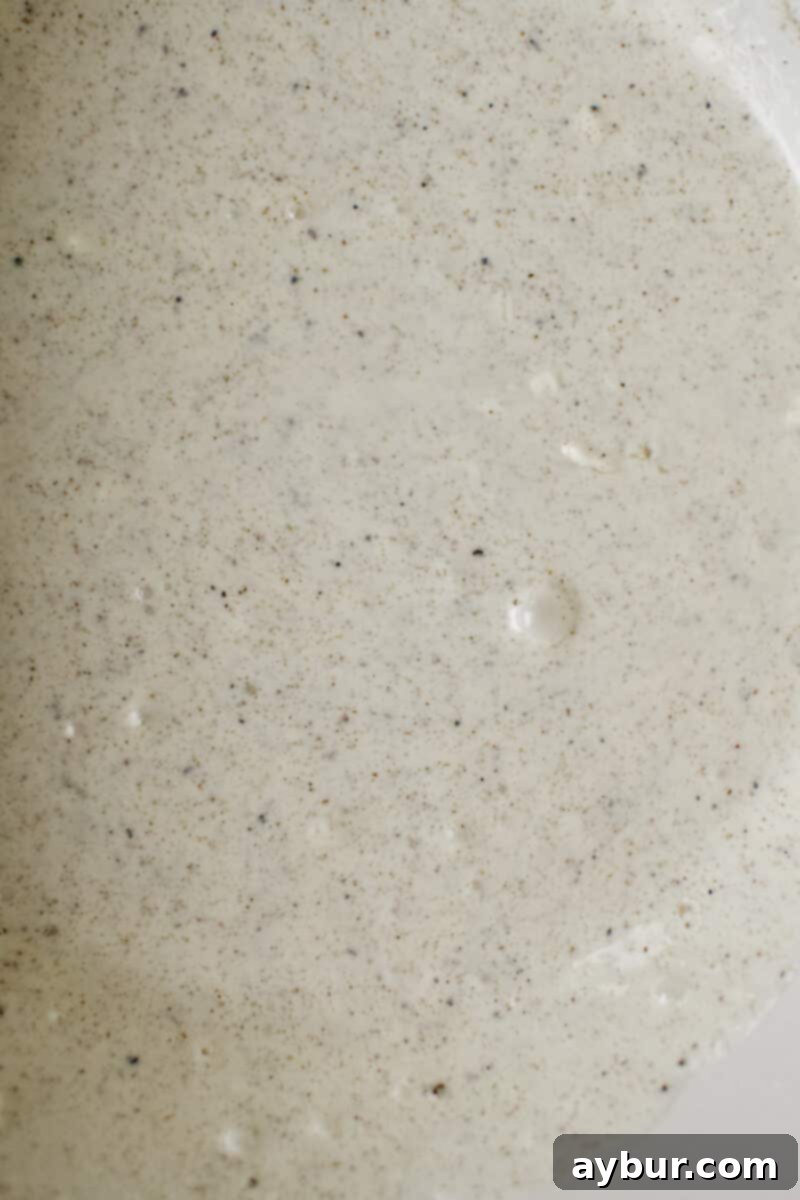 The creamy, tangy dressing for the red cabbage slaw, perfectly mixed in a large bowl, ready for the vegetables.