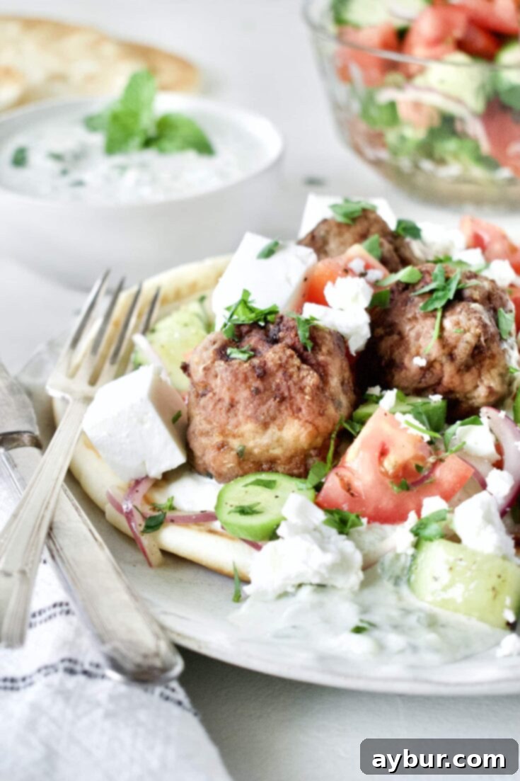 Greek Meatballs served with Greek Salad on top, over a pita bread with Tzatziki sauce.