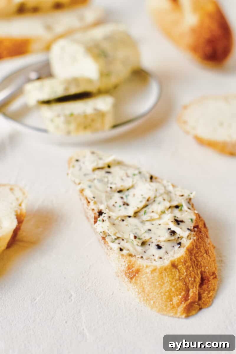 Gourmet Black Truffle Butter 9 A pristine, circular slice of Black Truffle Butter gently resting on a small, elegant plate, next to a matching knife and a couple of other prepared slices, ready to be served.