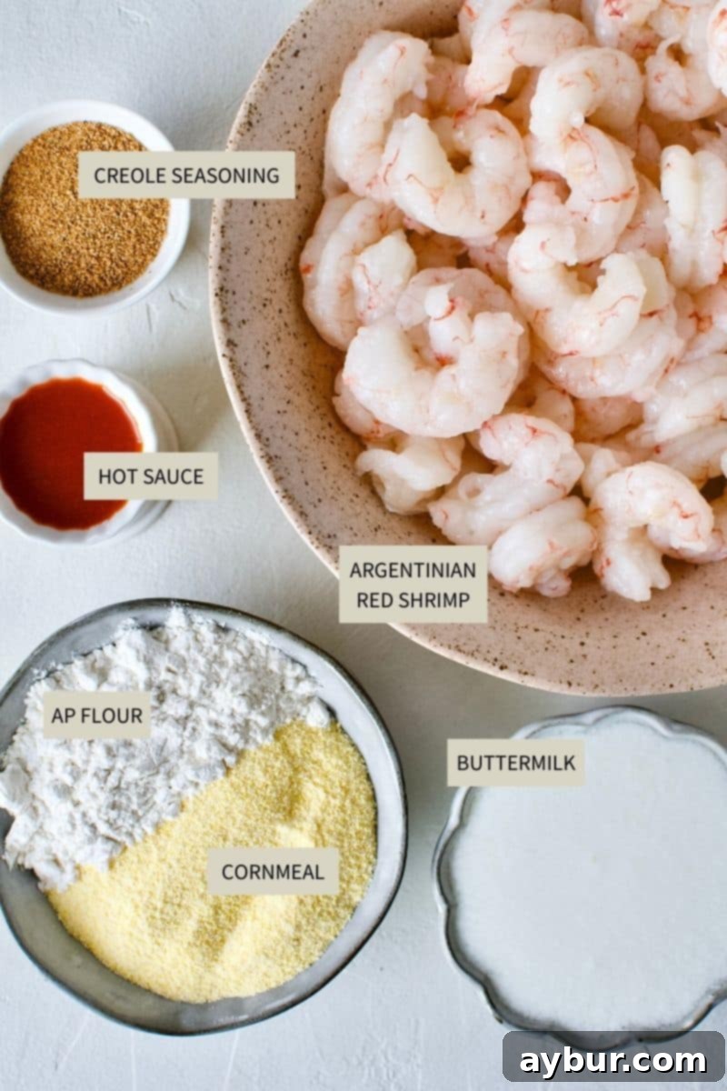 A collection of fresh ingredients including Argentinian red shrimp, buttermilk, flour, cornmeal, and Creole seasoning, essential for making Shrimp Po'boy Sandwiches.