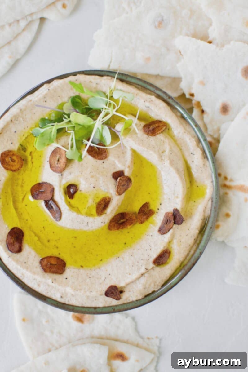 Smoky Baba Ghanoush with Golden Garlic 2 A bowl of Baba Ghanoush with Toasted Garlic, drizzled with olive oil and garnished with toasted garlic slices.