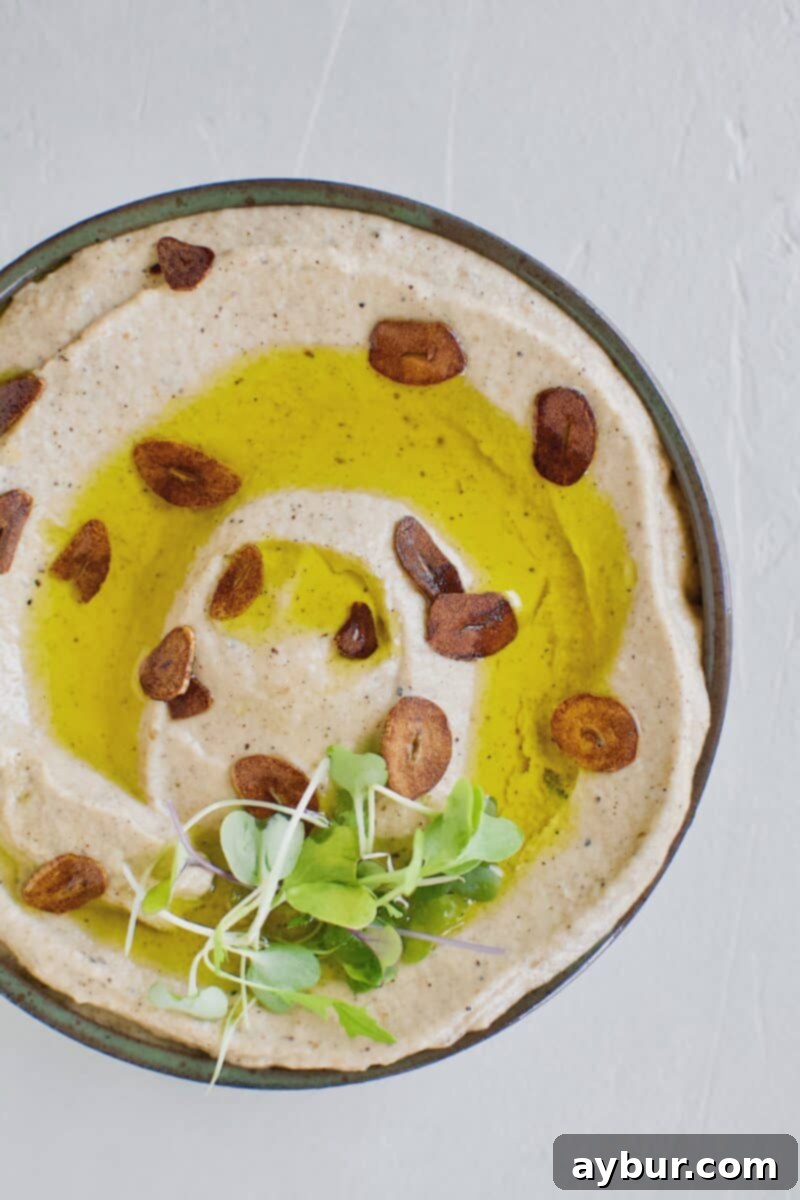 Smoky Baba Ghanoush with Golden Garlic 12 A beautifully presented bowl of Baba Ghanoush with Toasted Garlic, garnished with olive oil and golden garlic slices.