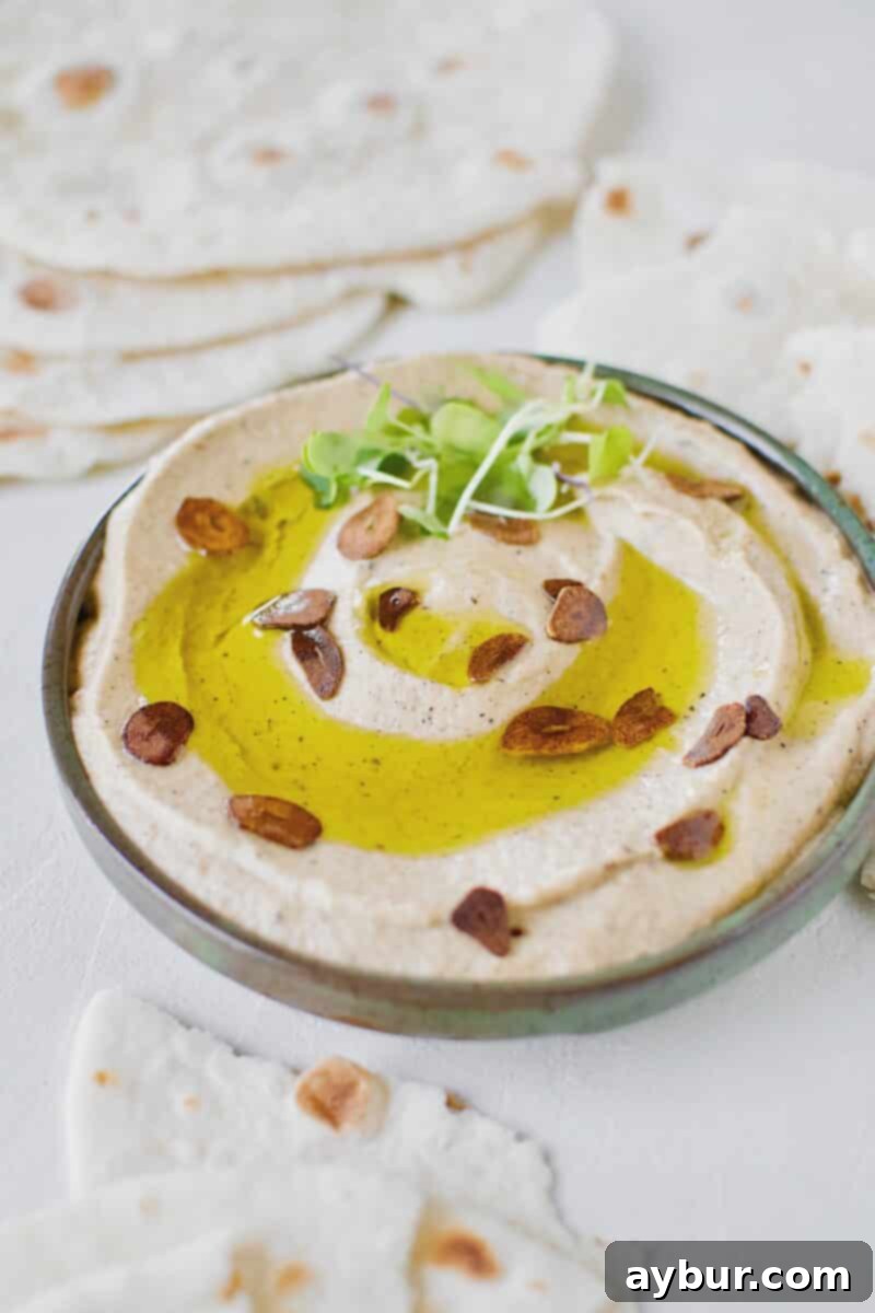 Smoky Baba Ghanoush with Golden Garlic 13 A bowl of Baba Ghanoush with Toasted Garlic, topped with olive oil and toasted garlic, ready to be served.