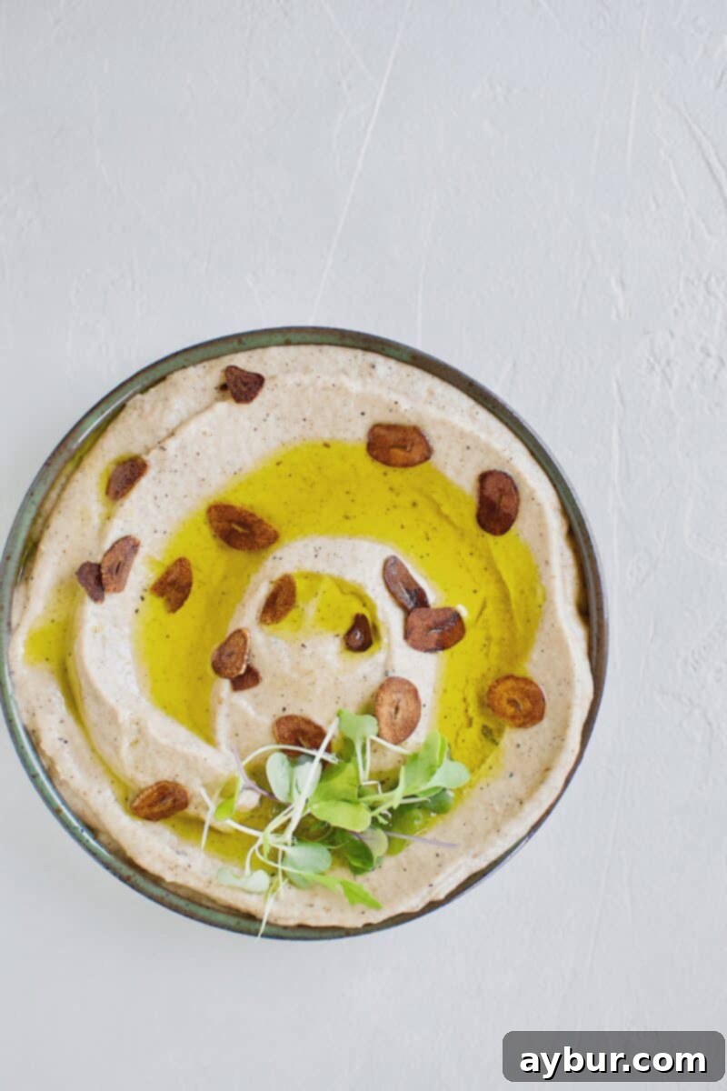 Smoky Baba Ghanoush with Golden Garlic 14 Close-up of Baba Ghanoush with Toasted Garlic in a bowl, showing the olive oil and garlic garnish.