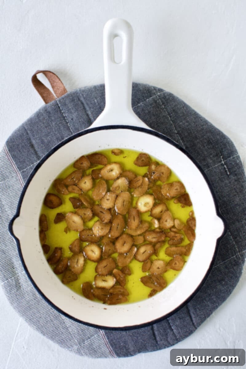 Smoky Baba Ghanoush with Golden Garlic 6 Golden-brown sliced garlic toasted in olive oil within a mini skillet.