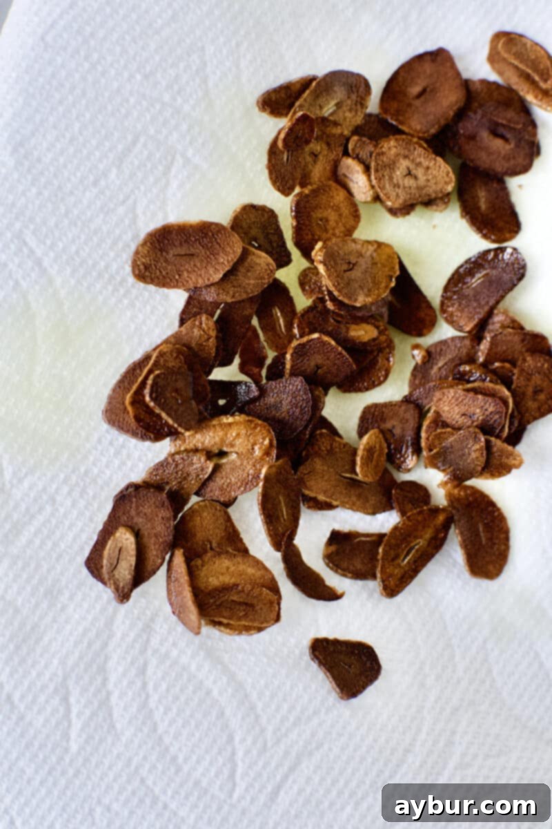 Smoky Baba Ghanoush with Golden Garlic 7 Toasted Garlic slices removed from oil and draining on a paper towel.