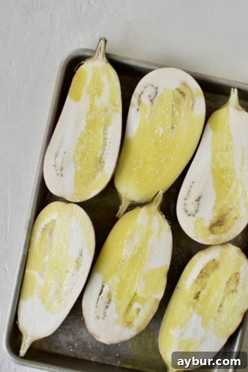 Smoky Baba Ghanoush with Golden Garlic 8 Eggplants tossed in garlic-infused oil and seasoned with salt, ready for grilling.