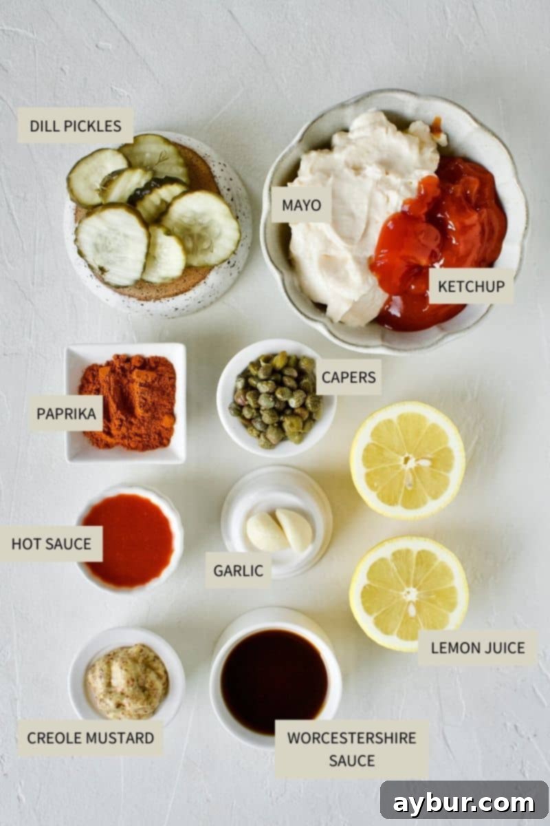 Effortless Remoulade Sauce 3 All ingredients laid out on a kitchen surface, ready to be combined for making Easy Remoulade Sauce: mayonnaise, ketchup, hot sauce, paprika, Creole mustard, Worcestershire sauce, dill pickles, capers, lemon, and garlic.